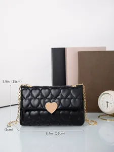 Detail of heart quilted black leather bag with gold heart buckle and chain strap