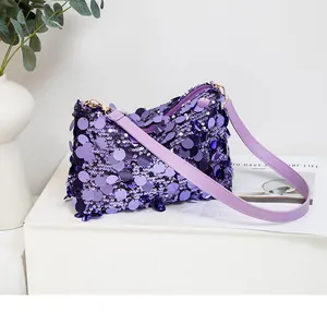 Detail view of shimmering purple sequins and leather strap on a chic shoulder bag