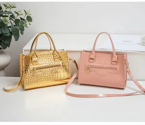 Details der Krokodilprägung auf goldenen und rosa Mini-Taschen aus Leder mit Reißverschluss