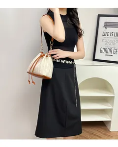 Détail du sac seau en paille avec tissage crème, base en cuir marron et bandoulière