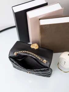 Close-up of black quilted crossbody bag with heart-shaped gold lock and chain strap