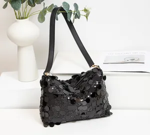 Detail of a chic black sequin shoulder bag with large reflective circular sequins