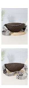 Detail of dark brown monogram chest bag with geometric woven strap and silver zipper closure