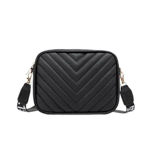 Classic black quilted crossbody camera bag with wide lettered strap and gold hardware