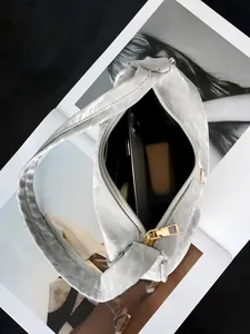 Detail der metallisch silbernen Faltentasche mit großem Stauraum und goldenem Reißverschluss
