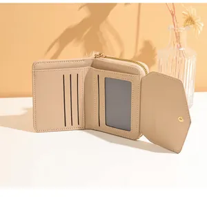 Detail of beige triple-fold wallet featuring three card slots and a golden metal zipper