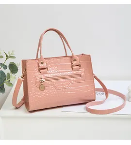 Nahaufnahme der rosa Handtasche mit glänzender Krokodilprägung und goldener Hardware