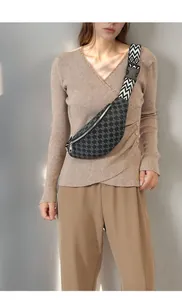 Detail of wide woven strap with geometric patterns and quick-release buckle on chest bag