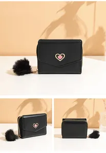 Close-up of black PU leather tri-fold wallet with gold heart buckle and faux fur pompom