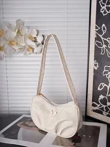 Detail der cremefarbenen Hobo-Tasche mit Schmetterlingsdekor und Sichelform-Design