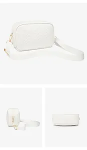 Detail view of white quilted crossbody bag with golden hardware and wide fabric strap