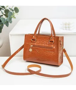Detailansicht der karamellbraunen Krokodil-Lederstruktur auf einer Handtasche