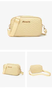 Close-up of cream crossbody bag with V-shaped wave quilting and adjustable strap