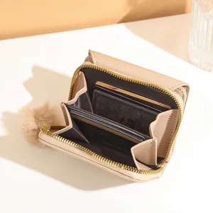 Women's minimalist beige leather wallet with gold zipper, pompom charm and multi-card slots