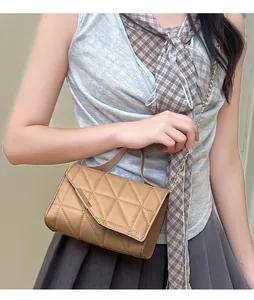 Detail of khaki shoulder bag featuring geometric triangle quilting and gold chain strap
