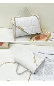 Detail of white quilted crossbody bag with golden chain strap and metallic bar closure