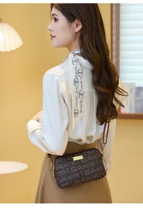 Detailed view of women's vintage crossbody bag with printed letters and gold metal logo