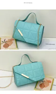 Close-up of light blue quilted handbag with triangular stitching and gold metal bar detail