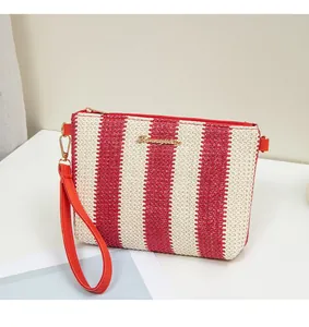 Close-up of red and white woven stripes texture with gold metal logo and zipper detail