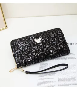 Dettaglio portafoglio lungo con paillettes nere e fibbia a farfalla dorata con zip