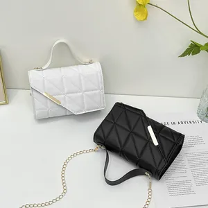 Chic quilted crossbody bag with golden trim and chain strap in black and white