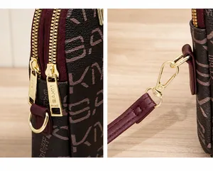 Detailed macro view of smooth dual golden zippers and detachable strap metal hooks on the bag