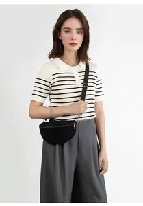 Modern black crescent crossbody bag with adjustable wide strap shown on a model