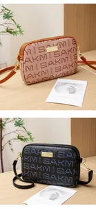 Close-up of double-zipper crossbody bags with letter print and gold metallic hardware