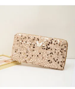 Dettaglio ravvicinato della texture con paillettes oro champagne e decoro a farfalla borsa