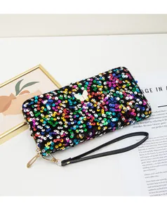 Dettaglio di una pochette lunga con paillettes, decoro a farfalla e cinturino nero