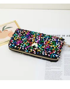Dettaglio macro della pochette con paillettes arcobaleno, farfalla 3D e zip dorata
