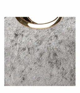 Macro detail of grey velvet handbag showing plush texture and gold round metal handle