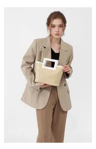Close-up of woven straw handbag with a white square handle and natural texture