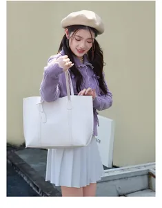 Detailed view of the soft white leather tote bag texture and long shoulder straps