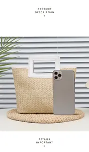 Detail view of woven straw tote bag with white faux leather handles and phone size comparison