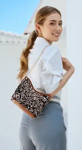 Detail of rose gold sequin bucket bag featuring metallic chain and premium leather trim