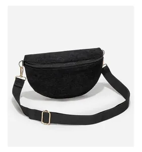 Detail of black corduroy crossbody bag with soft texture and gold metal zipper hardware
