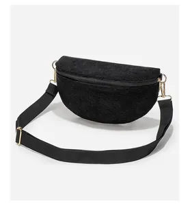 Detail of black corduroy crossbody bag showing fine texture and gold metal hardware