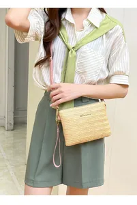 Dettaglio borsa a tracolla in paglia intrecciata beige con cinturino in pelle rosa