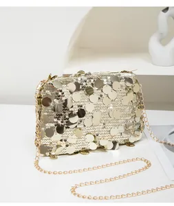 Detail of glittery gold sequin square clutch with fine metal chain strap for women