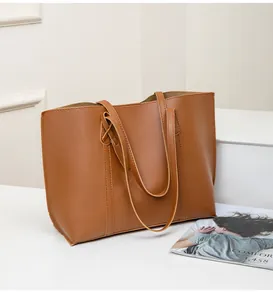 Close-up of soft brown leather tote bag with detailed stitching and long shoulder straps