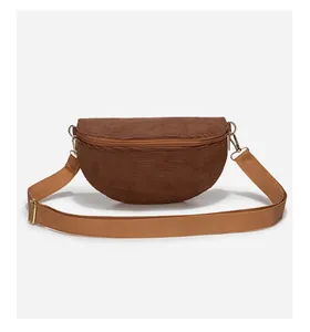 Detailed close-up of dark brown corduroy crossbody bag texture and metal zipper