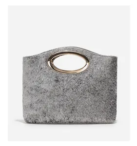 Detailed texture of grey matte felt handbag featuring oval gold metal handle