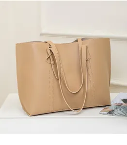 Detail showing high-quality beige soft leather texture and vertical stitching on tote bag