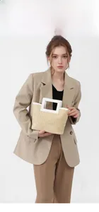 Detail of hand-woven straw tote bag with unique white square handle and beige texture