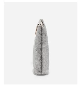 Side view of dark gray frosted handbag with round gold metal handle on white background