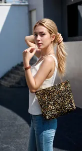 Detailed view of fashionable gold and black sequined shoulder bag with a gold chain strap