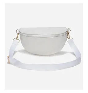 Detailed close-up of white corduroy crossbody bag texture with gold metal zipper hardware