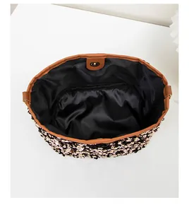 Close-up of sequin bucket bag interior with black lining and golden magnetic closure