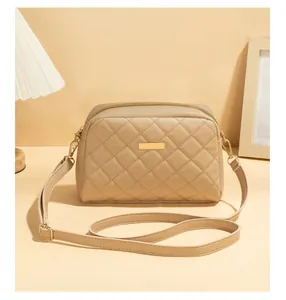 Detail der beigen Stepptasche mit goldenen Beschlägen und verstellbarem Lederriemen